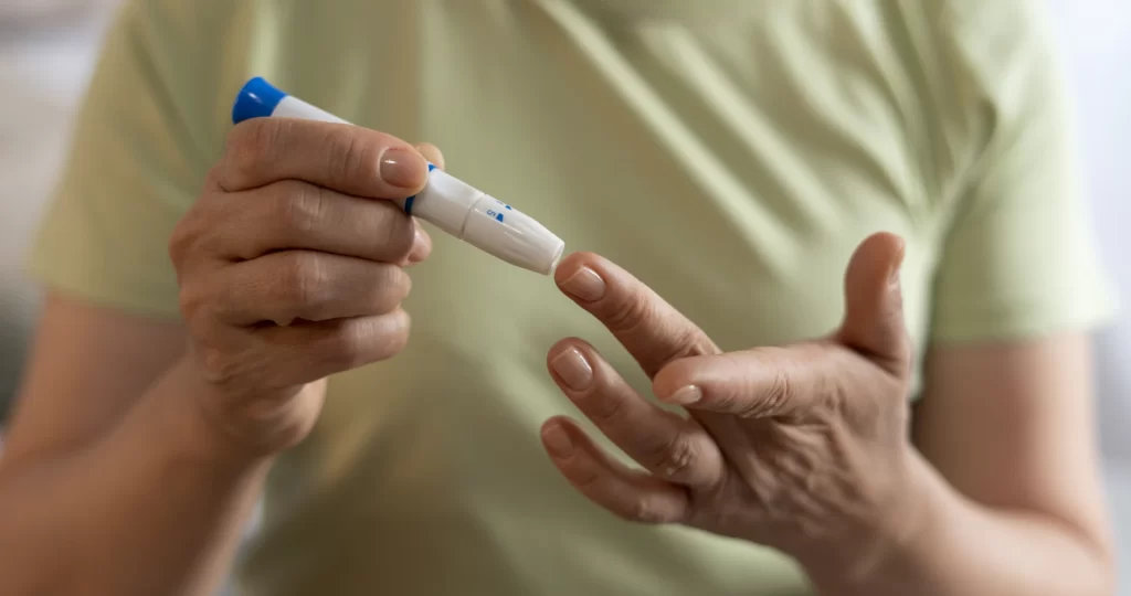 Pessoa medindo glicemia com lanceta, controlando os níveis de açúcar no sangue.
